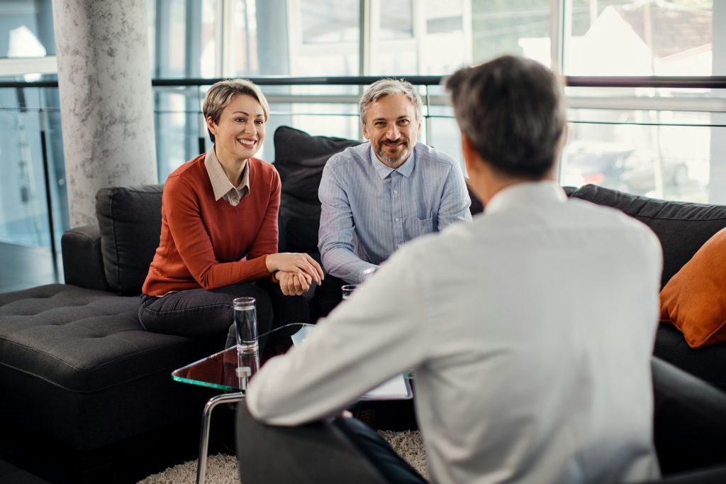 happy couple having a meeting with financial advisor in the office